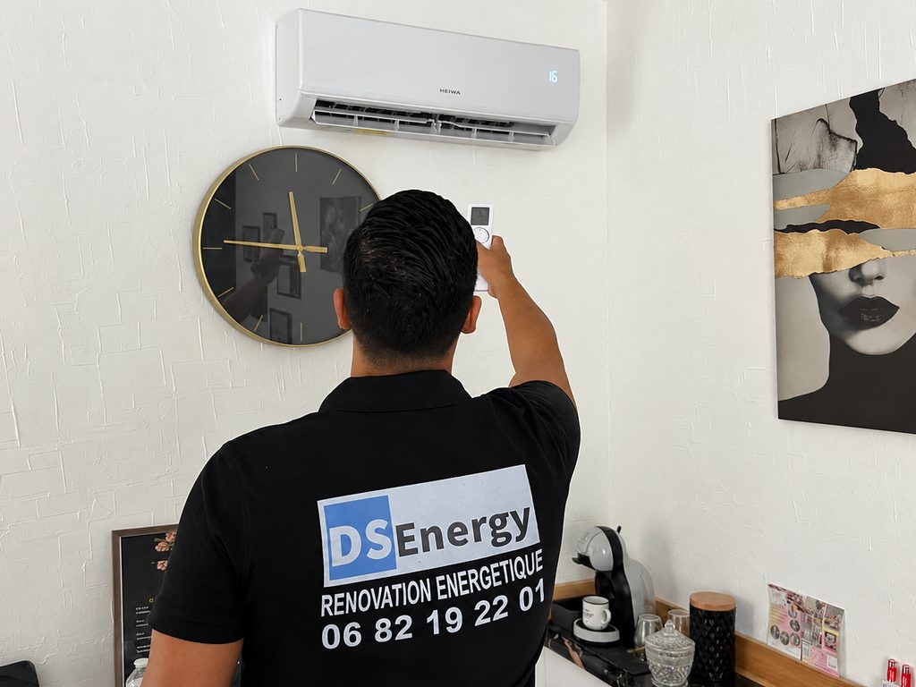 Technicien DS Energy testant une climatisation murale à la télécommande après installation